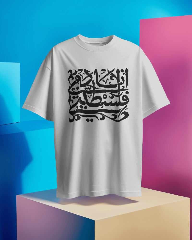 "Image of a white T-shirt printed with 'أنا دمي فلسطيني' in elegant black Arabic calligraphy. The phrase translates to 'My blood is Palestinian.' The T-shirt is made from high-quality 180 GSM cotton, offering a soft and durable fabric. The calligraphy design is intricate and bold, symbolizing cultural pride and resilience."